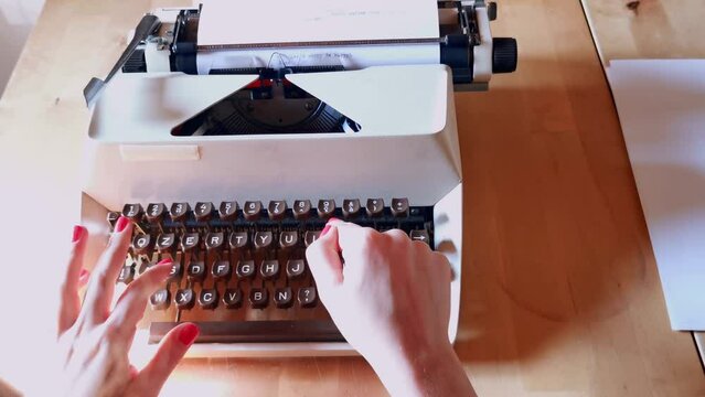 girls with red nail polish writing with antique typewriter