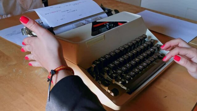 girls with red nail polish writing with antique typewriter