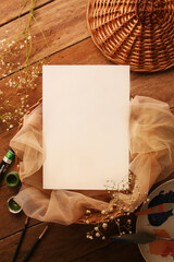 Blank paper on vintage wooden background. with stationary elements around. Flat lay top view.