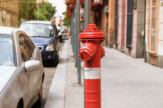 Red fire hydrant in city street. Fire hidrant for emergency fire access.
