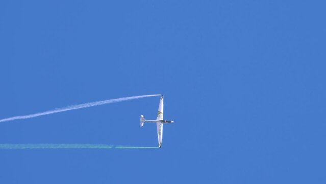 Aerobatic airshow  maneuvers against blue sky with smoke trail , Swift s1 airplane performing spins and rolls
