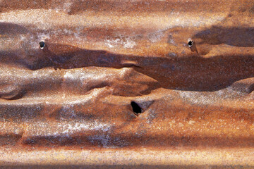 Brown abstract background with silver red hues. A weathered, rust-eaten, crumpled, perforated...