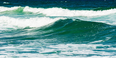 Fototapeta na wymiar green wave background in natural day light. blurred water and foam texture