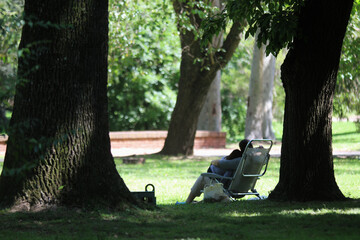 mae e filha sentadas em cadeira dobravel  na sombra das árvores em conexao com a natureza