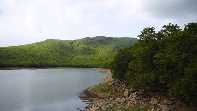 Willingdon Dam filled with water and lush green Girnar mountain on background at Junagadh, Gujarat, India. Beautiful nature during monsoon season. Monsoon landscape. 