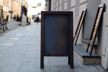 Signboard on the street. Empty menu board stand. Restaurant sidewalk sign board. Freestanding board near outdoor cafe. Copyspace for text, selective focus.