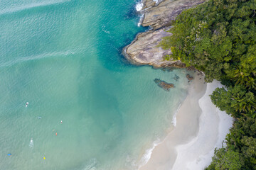 Imagem aérea de uma linda praia do litoral com a floresta tropical e águas claras 