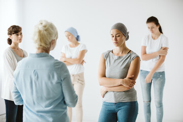 Meeting of group of women talking together during psychotherapy with senior counselor