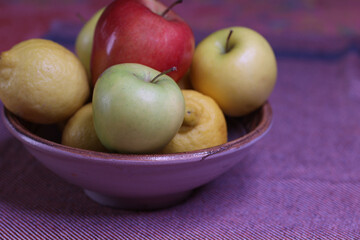 selective focus on whole  healthy  fruits in a purple bowl