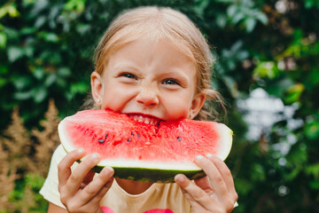 Happy funny child girl eats watermelon outdoor - obrazy, fototapety, plakaty