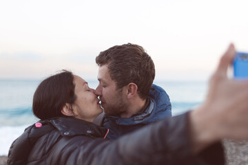 Fototapeta premium A man and a woman kiss on the beach