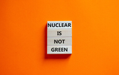 Nuclear is not green symbol. Concept words Nuclear is not green on wooden blocks. Beautiful orange table orange background. Nuclear is not green business concept. Copy space.