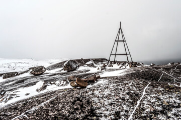 Iron structure on top of a snow-covered mountain