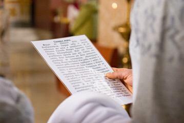 Naklejka premium person reading a page from a bible praying into the church 