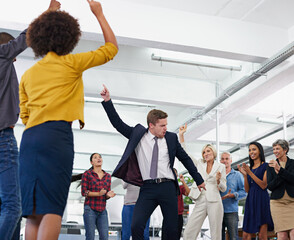 Putting some fun into the workplace. Cropped shot of an office party with people dancing and having...