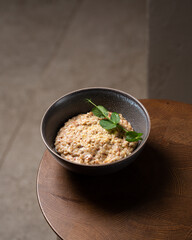 Buckwheat porridge in bowl with cheese on wooden background. Gluten free ancient grain for healthy diet. Top view. Copy space.