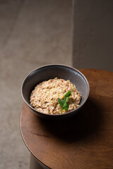Buckwheat porridge in bowl with cheese on wooden background. Gluten free ancient grain for healthy diet. Top view. Copy space.