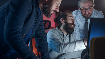 Fototapeta premium Three man colleagues employees cooperating in office talking working together at workplace, businessman coworkers discussing planning computer business project brainstorm in corporate teamwork