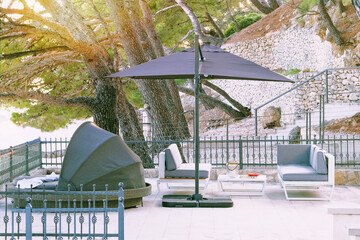 Beach umbrella and chaise for relax and comfort on balcony of hotel on sea coast. Happy summer...