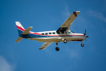 Fototapeta na wymiar Cessna 208b Grand Caravan G-BZAH light aircraft ascending from take off in a clear blue sky