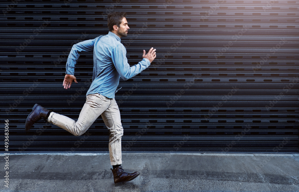 Poster chase after your dreams. shot of a handsome young man running in the city.