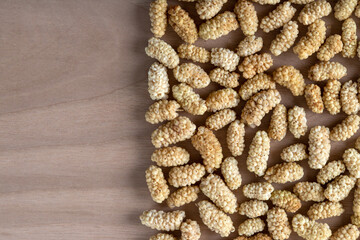 Pile of dried mulberry fruit on wooden background	