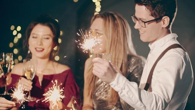 Asian girl and group young college student friends celebrating at glamorous party. Close-up of happy faces of young guys having rest together, clinking glasses of champagne. Millennials at party or