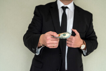 man in suit counting us money dollar