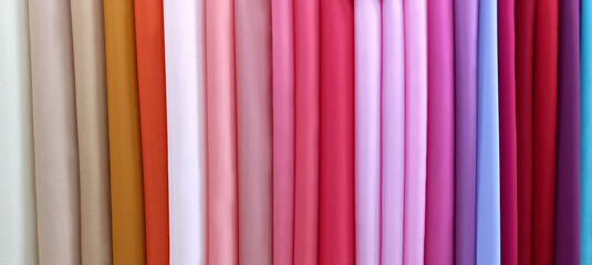 The assortment of silk fabrics in the store. Colorful, bright textiles. Collection of fabrics