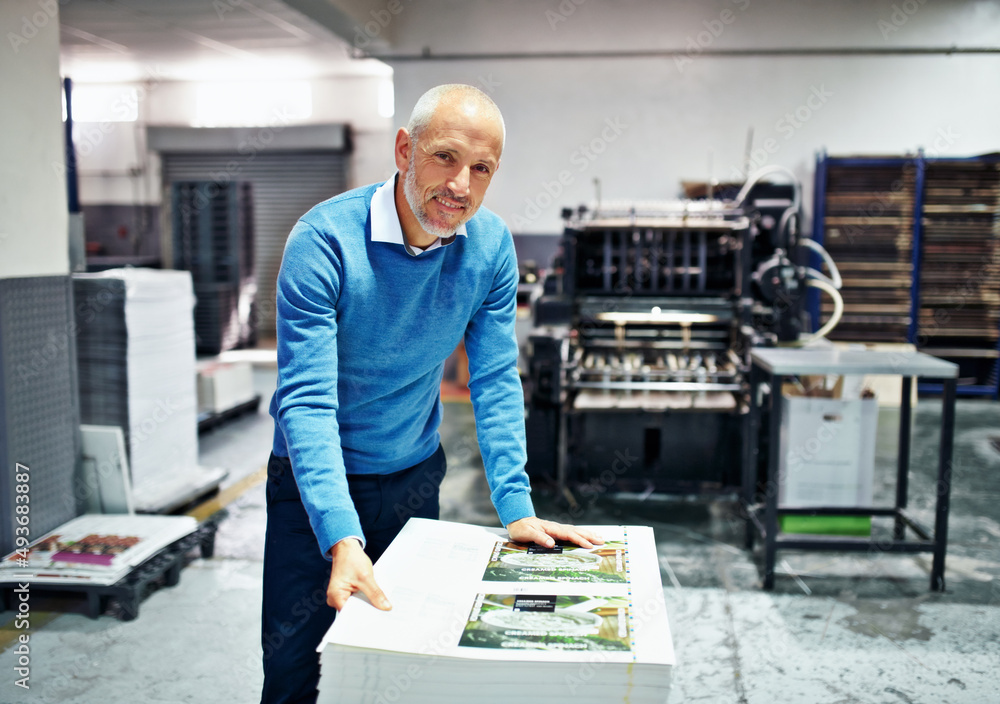 Fototapete the product is my reputation. portrait of a man checking the quality of a print run in a factory.