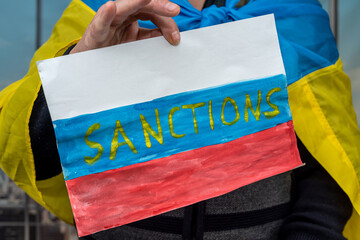 poster in male hands with text sanction for Russia