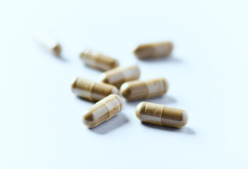 Gotu Kola (Centella Asiatica) capsules. Concept for a healthy dietary supplementation. Bright paper background. Soft focus. Close up. 