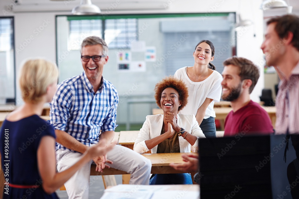 Poster getting along in the workplace. cropped shot of a group of designers having an informal office meeti