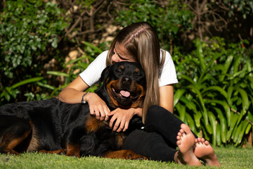 young girl Cuddling a teddy bear Rottweiler Positive emotions showing the attachment between human and pet love and trust and absolute endearment and enjoyment that exist in this relationship 