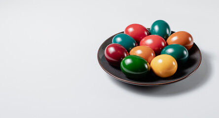 Ceramic plate with easter eggs on white background, stock photo