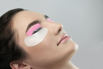 Master applies lash dye to eyelashes. Close-up of beauty model's face during lash lift laminating...