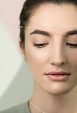 Eyebrow correction procedure. Brow shaping by thread depilation