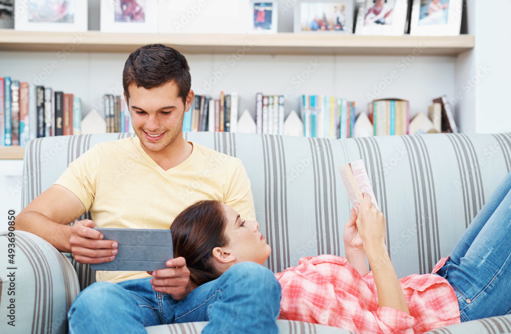 Canvas Prints Reading together. A young couple relaxing at home on the sofa.