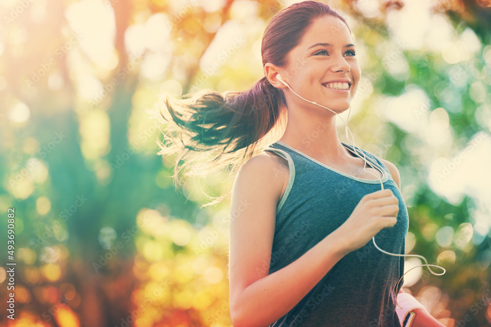 Wall mural Shes habitually healthy. Cropped shot of a young woman running in the park.