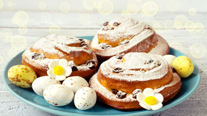 Delicious fresh pastries with icing sugar on a blue plate with chocolate sweet eggs for Easter gift