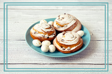 Delicious fresh pastries with icing sugar on a blue plate with chocolate sweet eggs for Easter gift