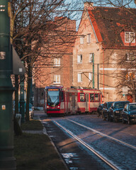 A tram going through the streets of Nowy Port in Gdańsk on a sunny morning. - obrazy, fototapety, plakaty