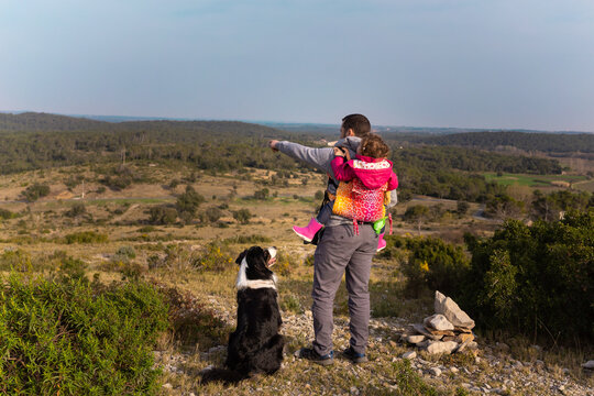 Dad with his daughter and dog hiking