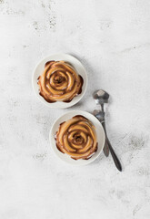 Italian dessert. Coffee Panna Cotta with chocolate sauce, in the shape of a rose, on a plate. Light background. Top view