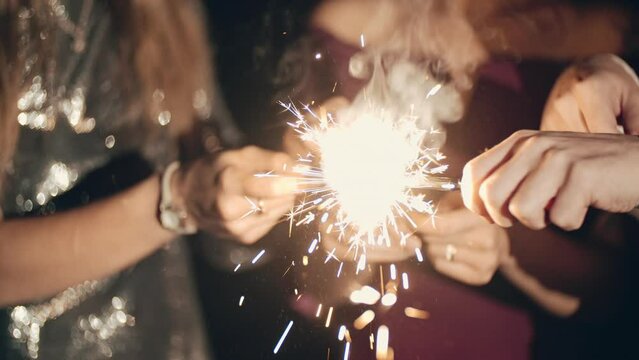 Hands or palms on black background seting fire to sparklers with lighter or fire, holding and waving sparklers or fireworks. Party on occasion of birthday, Party Party, Party Party or Party. Lifestyle