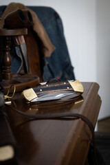 Pocket folding knife lying on table with compass in front of denim work coat