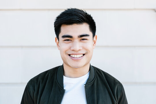 Young Asian Man Smiling Confidently At Camera While Standing On City Street - Ethnicity People Concept
