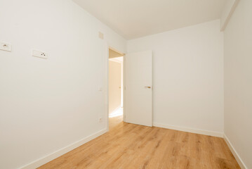 Empty living room with chestnut hardwood floorboards and freshly painted walls