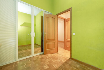 bedroom with white wooden wardrobe with venetian and mirror doors, oak parquet flooring and matching doors
