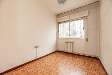 Empty room with aluminum radiator for sale with bars and shutters